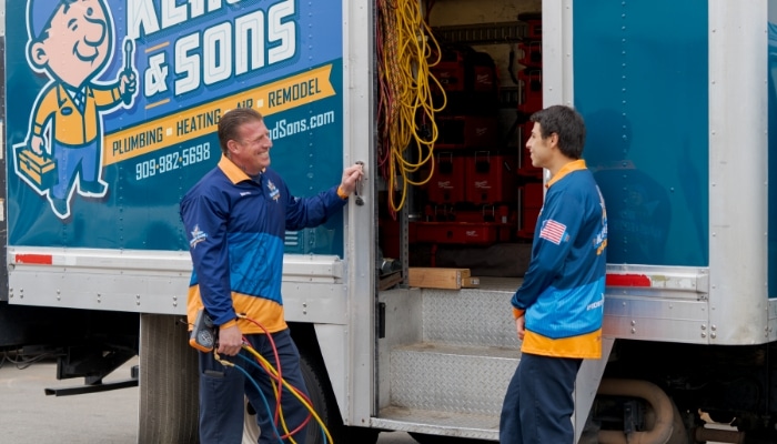Klaus And Sons Technicians Talking Outside Van