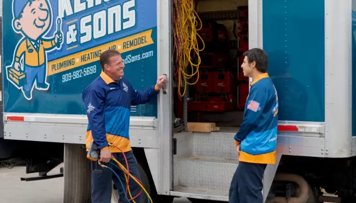 Klaus And Sons Technicians Talking Outside Van