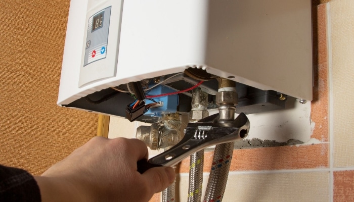 Plumber Working On A Tankless Hot Water Heater