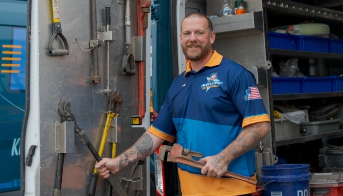 Technician Smiling Holding Plumbing Wrench