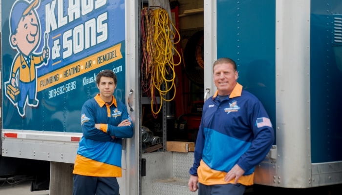 Two Technicians Leaning On Trucks