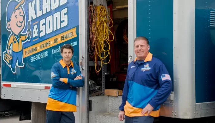 Two Technicians Leaning On Trucks